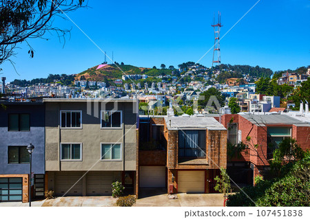 Sutro Tower up on hill on blue sky day with houses down below on hillside Sutro Tower up on hill on blue sky day with houses down below on hillside 107451838