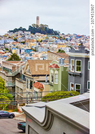 Houses and apartments leading to distant Coit Tower on overcast day Houses and apartments leading to distant Coit Tower on overcast day 107451907