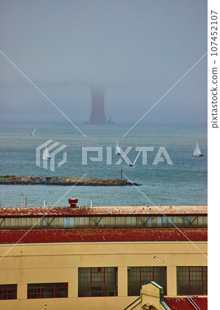 Warehouse with boats on San Francisco Bay with foggy and obscured Golden Gate Bridge Warehouse with boats on San Francisco Bay with foggy and obscured Golden Gate Bridge 107452107