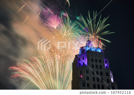 Zoomed in view of dazzling fireworks behind Lincoln Tower with purple and blue lights in Fort Wayne 107452118