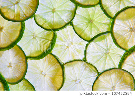 Wall of overlapping green lime slices in background asset of citrus fruit Wall of overlapping green lime slices in background asset of citrus fruit 107452594