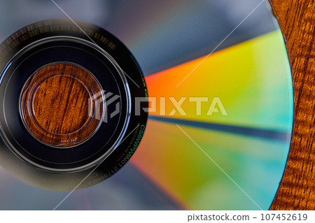 Orange light fading to teal blue on two triangular beams racing out from black center of CD Orange light fading to teal blue on two triangular beams racing out from black center of CD 107452619