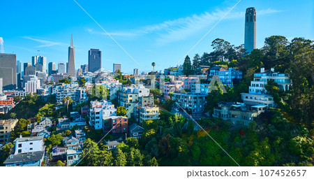 Telegraph Hill with Coit Tower aerial on blue sky day with distant San Francisco skyscrapers Telegraph Hill with Coit Tower aerial on blue sky day with distant San Francisco skyscrapers 107452657