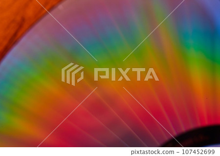 Brilliant rainbow streams of light close up of CD surface in abstract shot Brilliant rainbow streams of light close up of CD surface in abstract shot 107452699