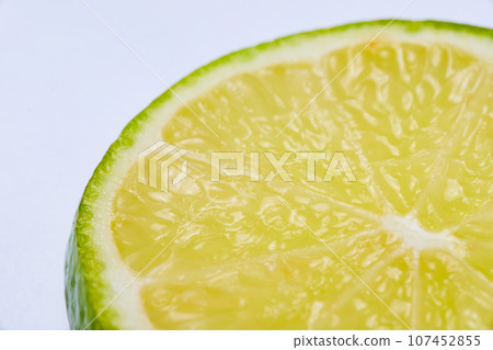 Close up of green lime slice inner flesh against white background 107452855