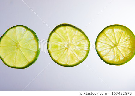 Three green lime slices close up on white background 107452876