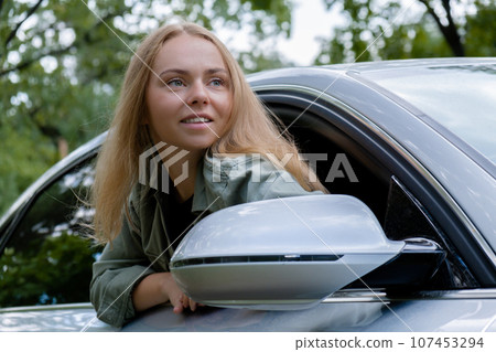 Blonde woman sticking head out of windshield car. Young tourist explore local travel making candid real moments. True emotions expressions of getting away and refresh on open clean air Blonde woman sticking head out of windshield car. Young tourist explore local travel making candid real moments. True emotions expressions of getting away and refresh on open clean air 107453294