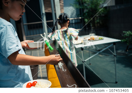 Somen noodles flowing down the rain gutter in the garden Somen noodles flowing down the rain gutter in the garden 107453405