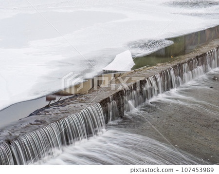 A small flat cascade in a calm river 107453989