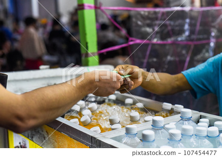 Tourist giving malaysian ringgit money to a malaysian seller to buy fresh juice in the Jalan Alor street food Tourist giving malaysian ringgit money to a malaysian seller to buy fresh juice in the Jalan Alor street food 107454477