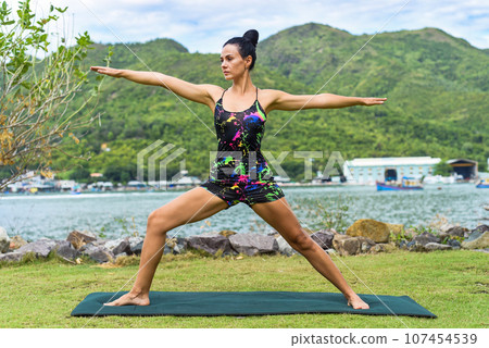 Warrior 2 pose or Virabhadrasana 2 yoga with ukrainian woman making it outdoors 107454539
