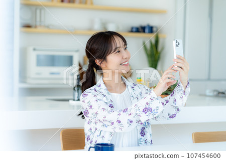 A young woman operating a smartphone A young woman operating a smartphone 107454600