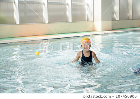 girl playing in the pool 107456906