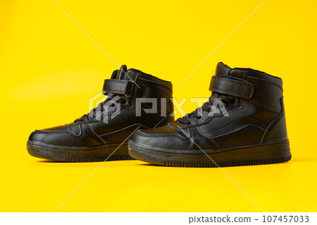 Black new sport sneakers on yellow background Black new sport sneakers on yellow background 107457033