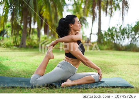 full pigeon pose (mermaid pose) or eka pada rajakapotasana yoga with ukrainian woman making it outdoors 107457269