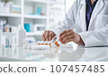 Close-up of a female pharmacist sitting at the desk in a drugstore 107457485
