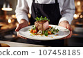 Chef holding plate with delicious roasted duck fillet on table in restaurant 107458185