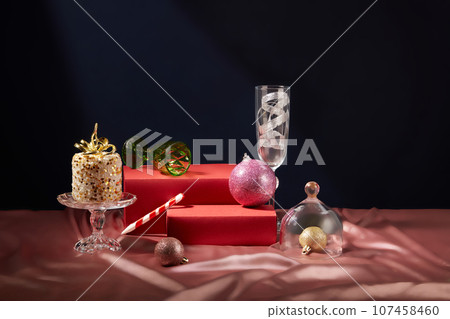 Two red pedestals in rectangle shaped decorated with small and large baubles. Glasses and a candle featured. Christians would follow the gift-giving tradition on Christmas Two red pedestals in rectangle shaped decorated with small and large baubles. Glasses and a candle featured. Christians would follow the gift-giving tradition on Christmas 107458460