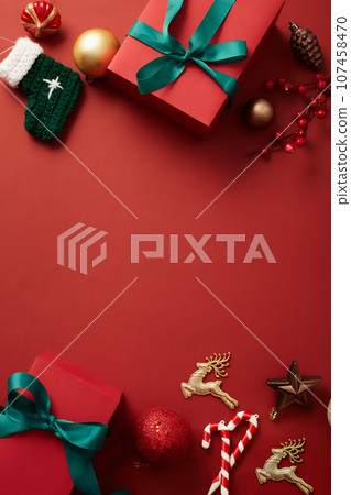 Red background featured a lot of Christmas ornaments. Blank space in the middle for product or text adding. Traditional Christmas greetings include Merry Christmas and Happy Christmas 107458470