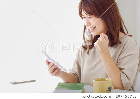 一個年輕女子很高興地看著計算器 107459712