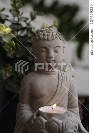 stone statue of buddha with a candle stone statue of buddha with a candle 107459829