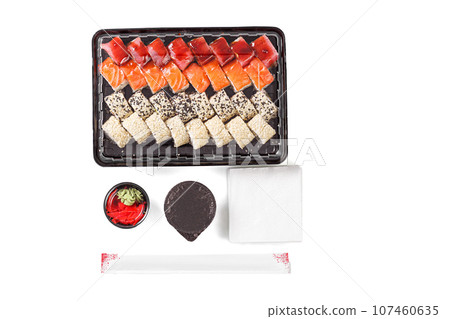 A set of sushi in a delivery box, soy sauce, chopsticks, wasabi, ginger on a white background 107460635