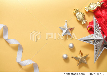 Xmas background with decorations display on yellow background. Ribbon, baubles and star decorated, create blank space for presentation product and copy space. Top view, flat lay. Xmas background with decorations display on yellow background. Ribbon, baubles and star decorated, create blank space for presentation product and copy space. Top view, flat lay. 107460712
