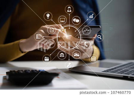 Businesswoman working with smartphone and using a calculator to calculate the numbers of static in office. Finance accounting concept. Businesswoman working with smartphone and using a calculator to calculate the numbers of static in office. Finance accounting concept. 107460770