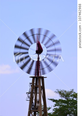 Windmill shines in the blue sky 107462988
