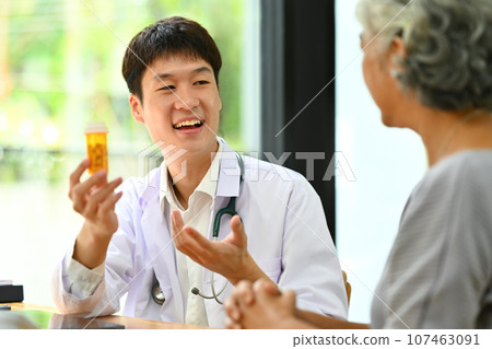 Medical worker or GP prescribing pills to an older female patient. Medicine and health care service concept Medical worker or GP prescribing pills to an older female patient. Medicine and health care service concept 107463091