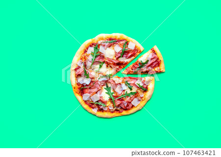 Homemade pizza with prosciutto, above view on a green table 107463421