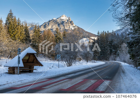 Road in a winter mountain snowy landscape. Road in a winter mountain snowy landscape. 107464076