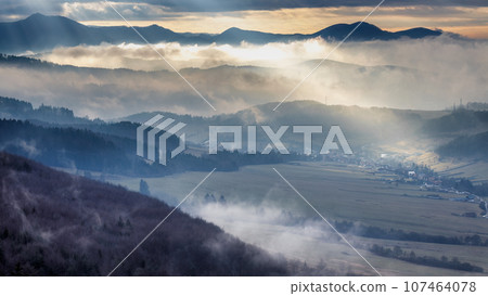 Mountainous landscape with misty valleys at dramatic light. Mountainous landscape with misty valleys at dramatic light. 107464078