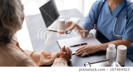 Doctor or physician recommend pill medical prescription to elderly female patient 107464925