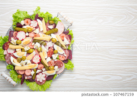 Fiambre, salad of Guatemala, Mexico and Latin America, on large plate top view white wooden background top view. Festive dish for All Saints Day (Day Of The Dead) celebration Fiambre, salad of Guatemala, Mexico and Latin America, on large plate top view white wooden background top view. Festive dish for All Saints Day (Day Of The Dead) celebration 107467159