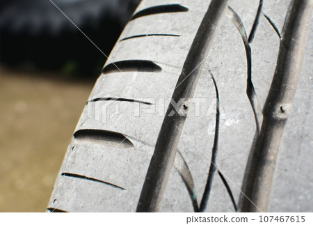 Tire tread wear indicator, Close up of tire with tire tread wear indicator showing on tread grooves. 107467615