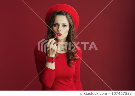 modern female in red dress and beret with red lipstick 107467822