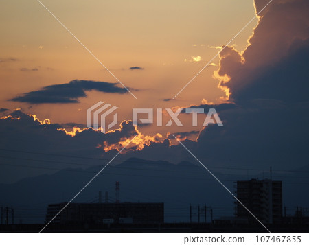 Silhouettes of cumulonimbus clouds illuminated by the summer sunset Silhouettes of cumulonimbus clouds illuminated by the summer sunset 107467855