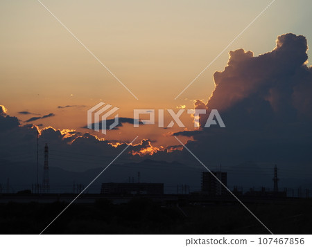 Silhouettes of cumulonimbus clouds illuminated by the summer sunset Silhouettes of cumulonimbus clouds illuminated by the summer sunset 107467856
