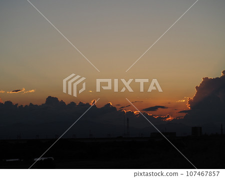 Silhouettes of cumulonimbus clouds illuminated by the summer sunset Silhouettes of cumulonimbus clouds illuminated by the summer sunset 107467857