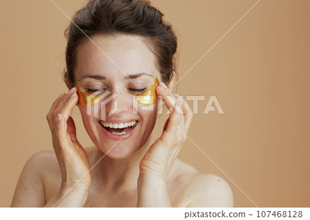 happy modern woman with eye patches on beige background happy modern woman with eye patches on beige background 107468128