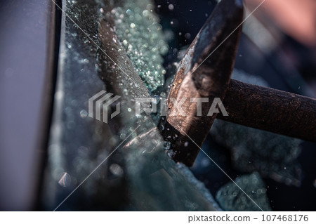 Car thief breaks the car window 107468176