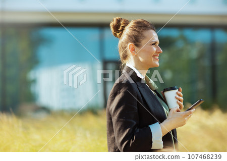 happy female employee in business district using smartphone 107468239