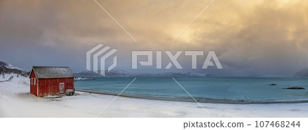 Winter Norway landscape with rorbu on the ocean beach and snow Winter Norway landscape with rorbu on the ocean beach and snow 107468244