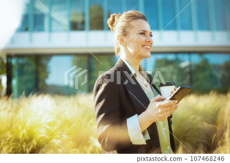 smiling woman worker in business district using smartphone smiling woman worker in business district using smartphone 107468246