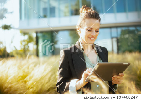 happy modern woman worker in business district using tablet PC 107468247