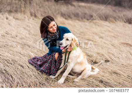 Smiling woman with cute dog on early spring nature 107468377