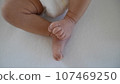 Newborn baby's legs and tiny feet. 107469250