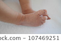 Newborn baby's legs and tiny feet. 107469251