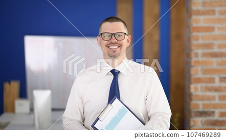 Portrait of young smiling businessman in glasses in office Portrait of young smiling businessman in glasses in office 107469289
